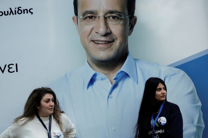 Supporters of Cyprus presidential candidate Nikos Christodoulides are seen in front of a poster in Nicosia